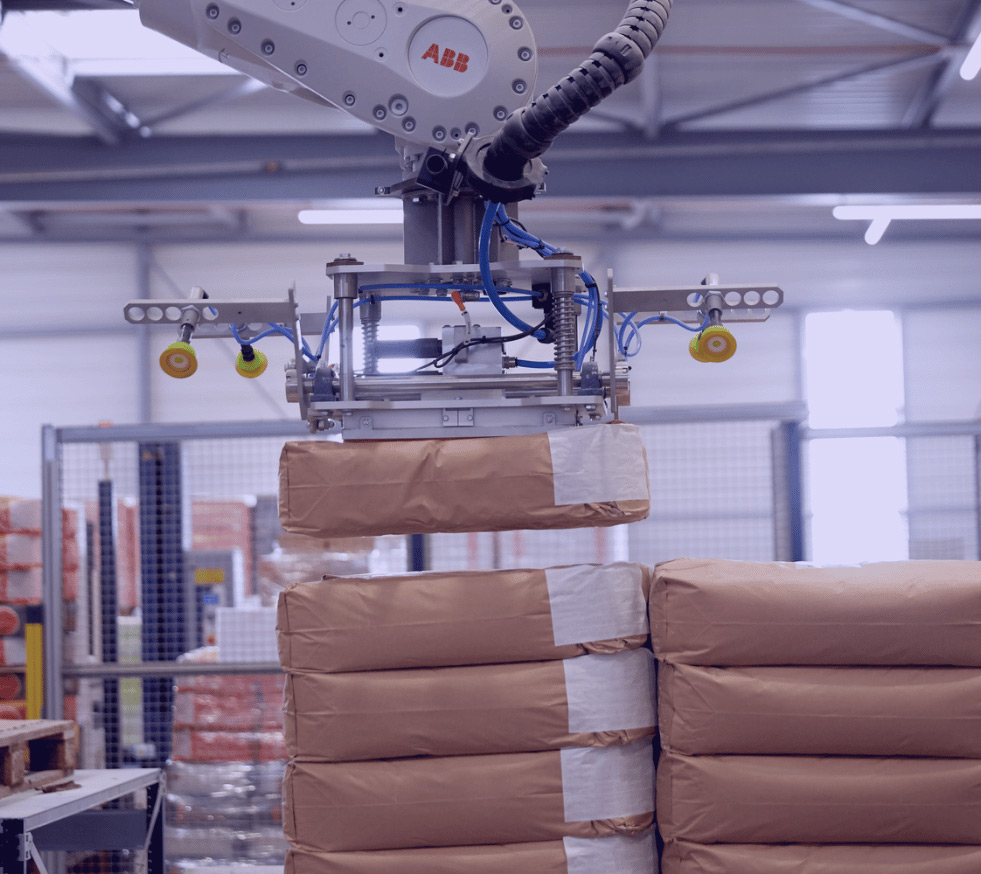 Préhenseur multiformat maintenant en l'air un sac de farine grâce à un caisson d'aspiration.