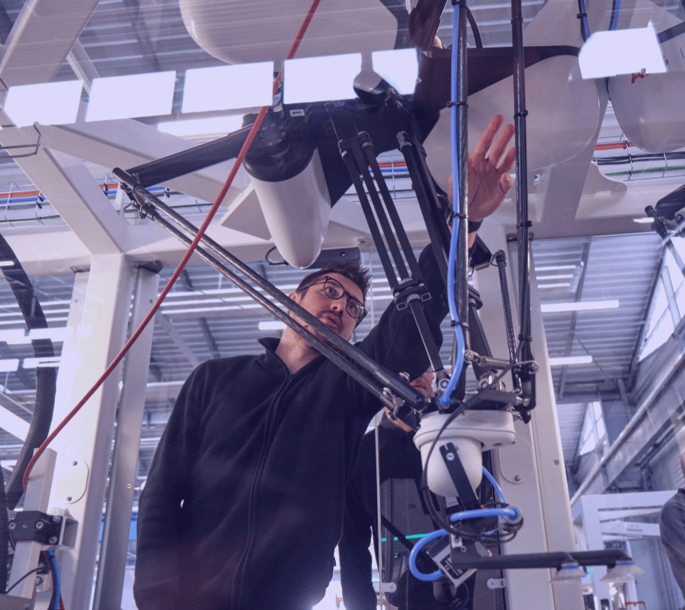Robot delta au bout du quel se trouve un préhenseur à ventouse.